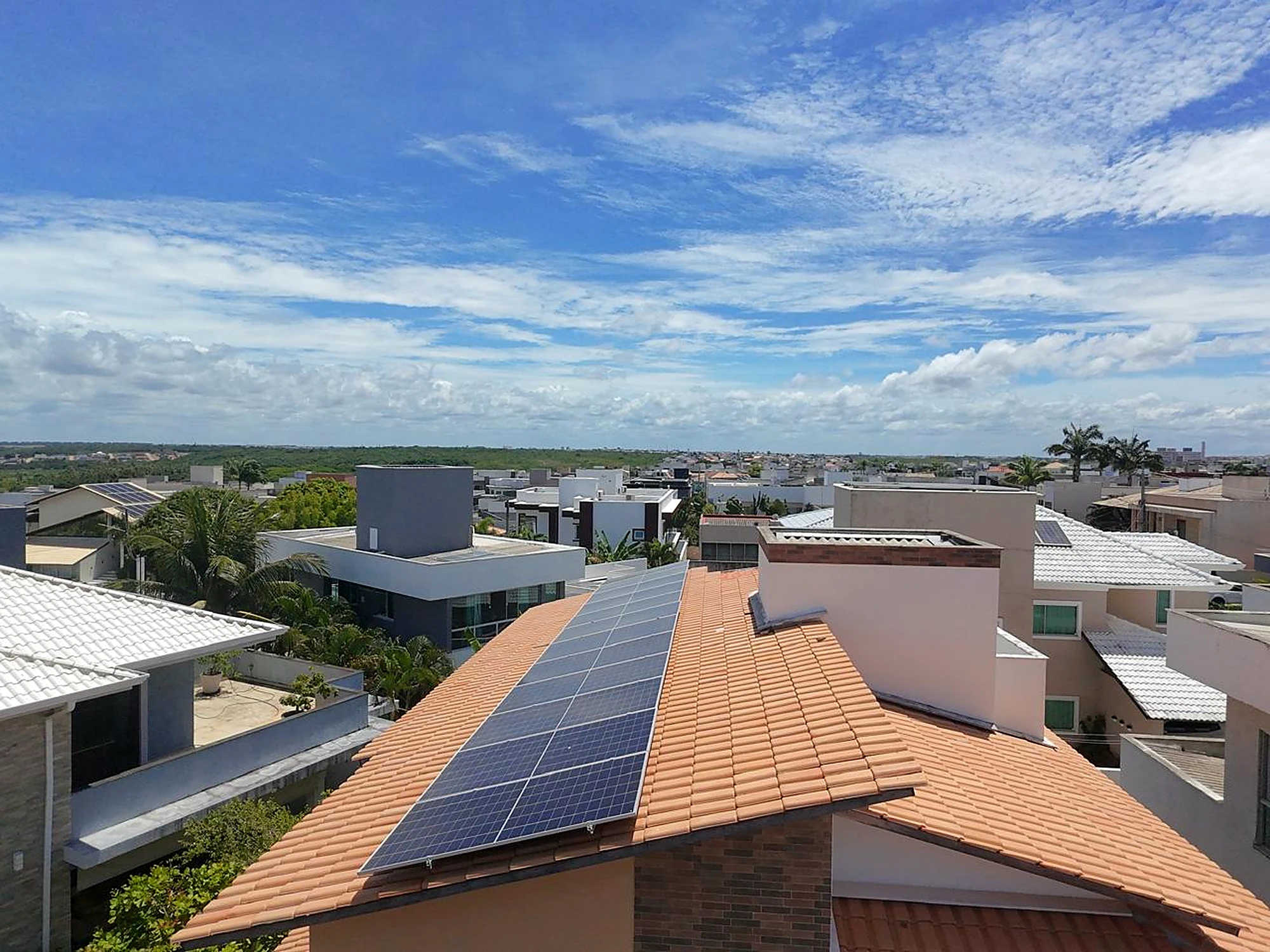 Painéis solares em telhado de residência com céu aberto